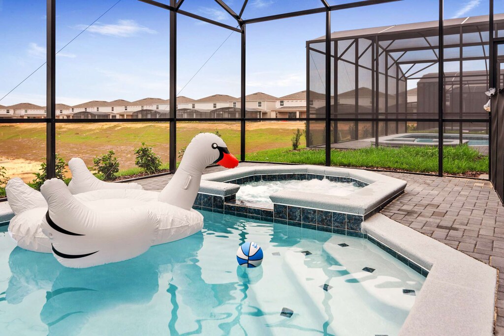 Relax in your private screened pool with a fun swan float and spa. Perfect for family enjoyment and relaxation.