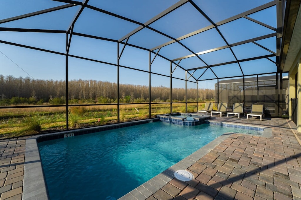 Relax in your private screened-in pool and hot tub with serene views of nature, perfect for a peaceful getaway.