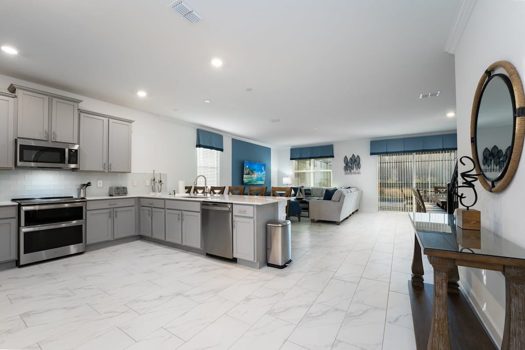 Experience modern comfort in this open-plan kitchen and living area, perfect for relaxing and entertaining.