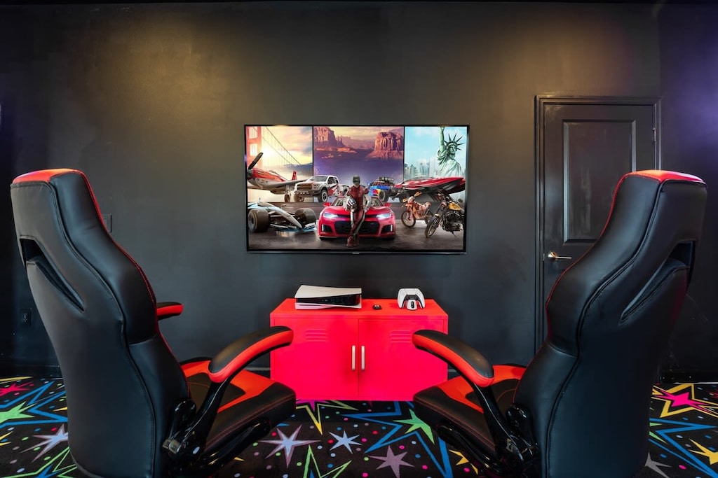 Immerse yourself in the ultimate gaming experience with state-of-the-art chairs and a large screen in this vibrant game room.