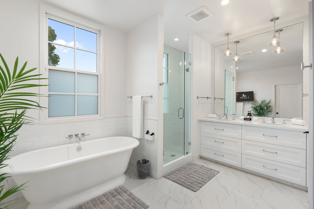 Primary spa en-suite with soaking tub and glass shower