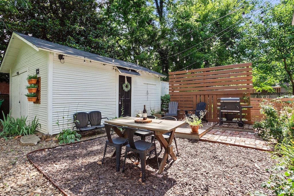 Our outside patio and garden shed area is ultimate cottage feels. Featuring a BBQ grill, picnic table dining seating, overhead string lights, lounge chairs, and tons of plant life.