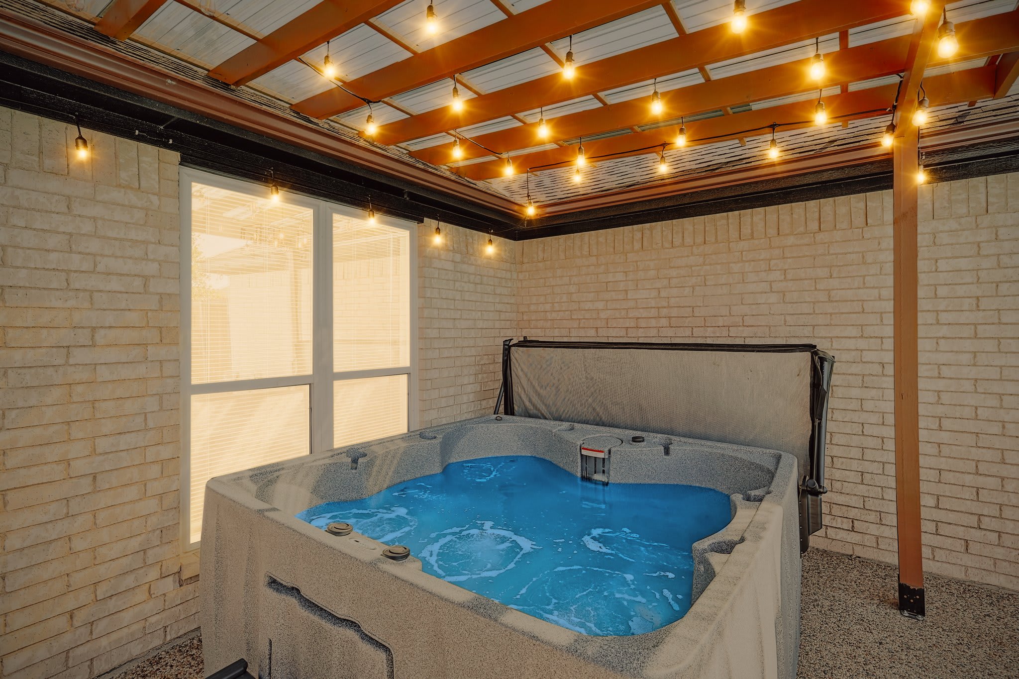 You’ll instantly feel the tension slip off your shoulders as you slip into this jacuzzi and relax under the warm glow of the string lights.