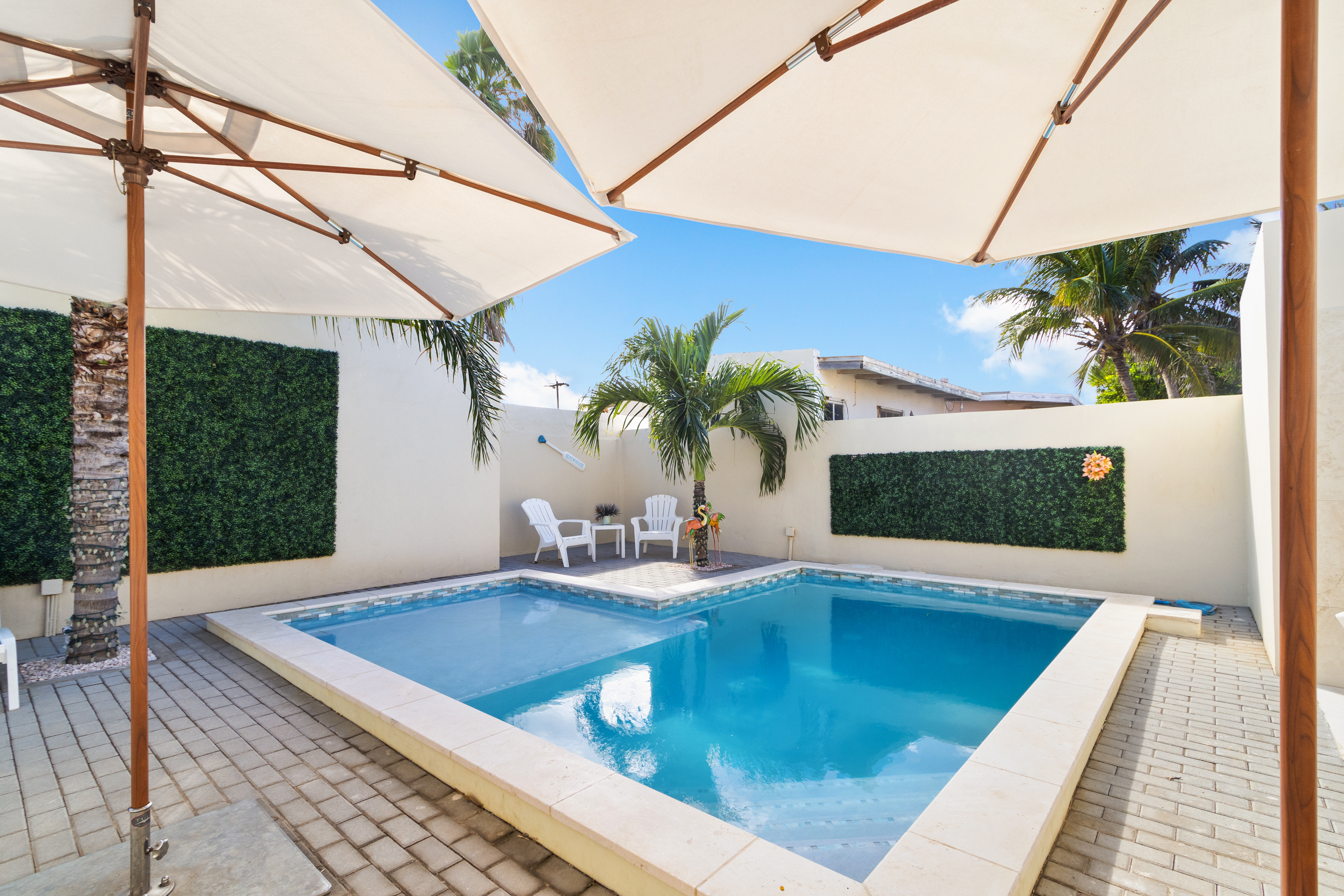 Refreshing Shared Pool of the Apartment in Noord, Aruba - Cosy beach chairs available - Dive into refreshing poolside escape - Immerse yourself in the cool elegance of our pool with umbrella shades - Experience ultimate relaxation in our poolside