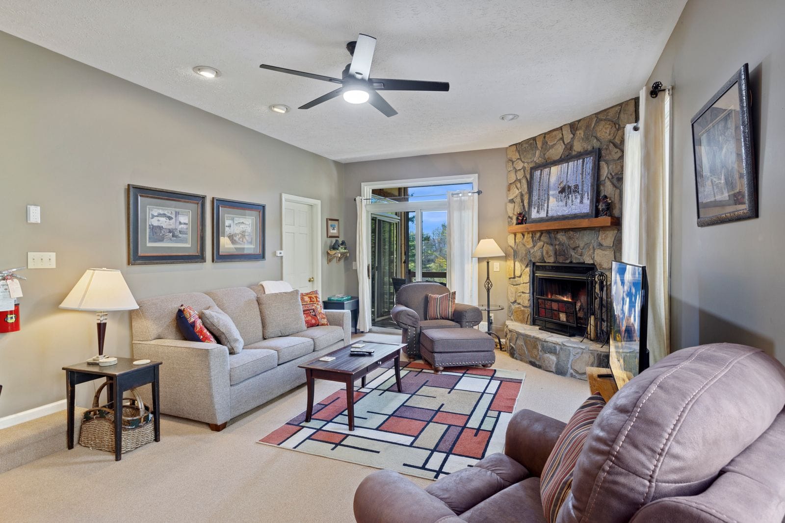 Main Living Room with Comfy Seating, Fireplace, Deck Access, and Large TV