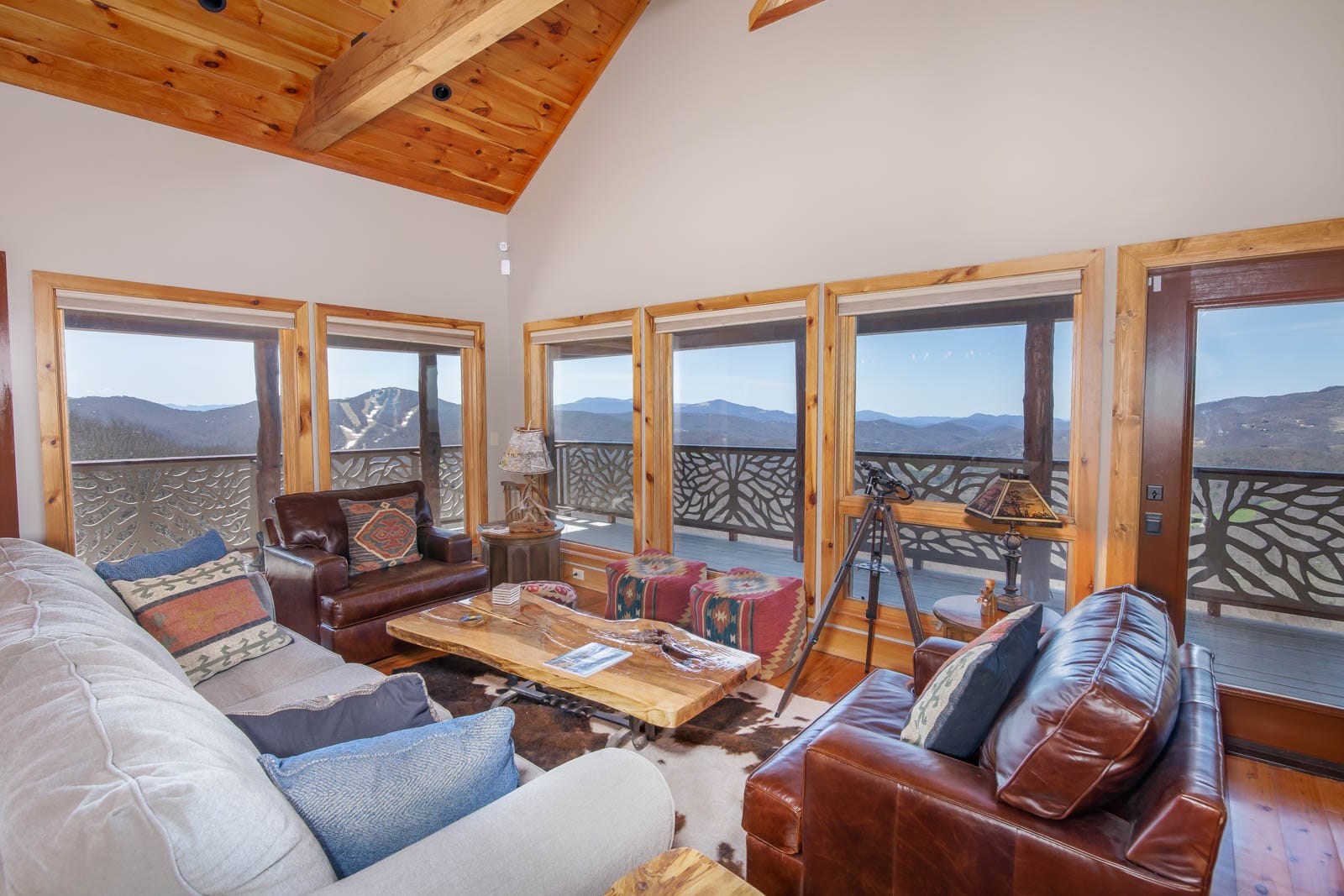 Great Room at Divine View with Designer Furniture and a Wall of Windows Which Frame Mountain Views