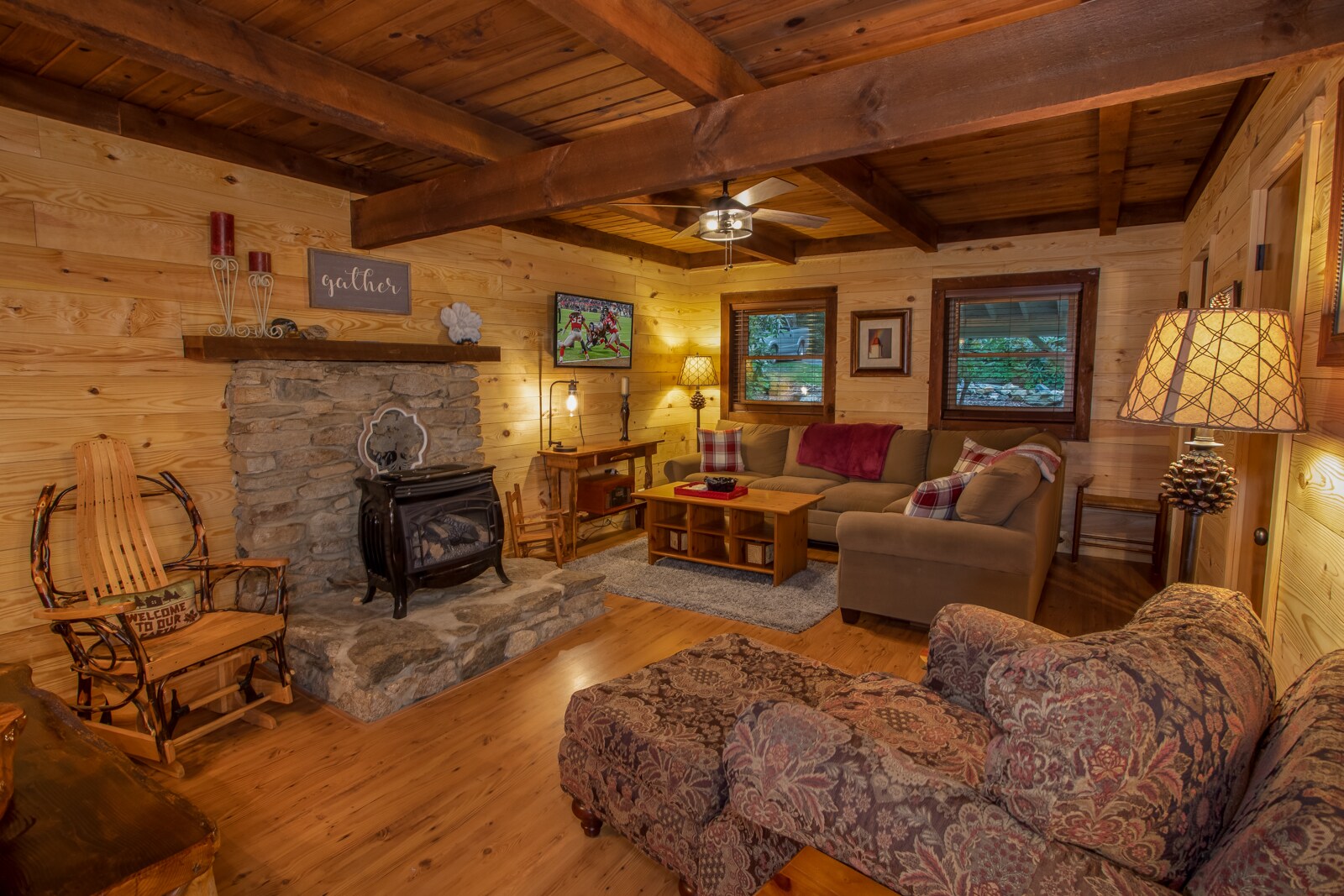 Cozy Living Room with Gas Buck Stove, HD Smart TV, Exposed Beams, and Comfy Furniture