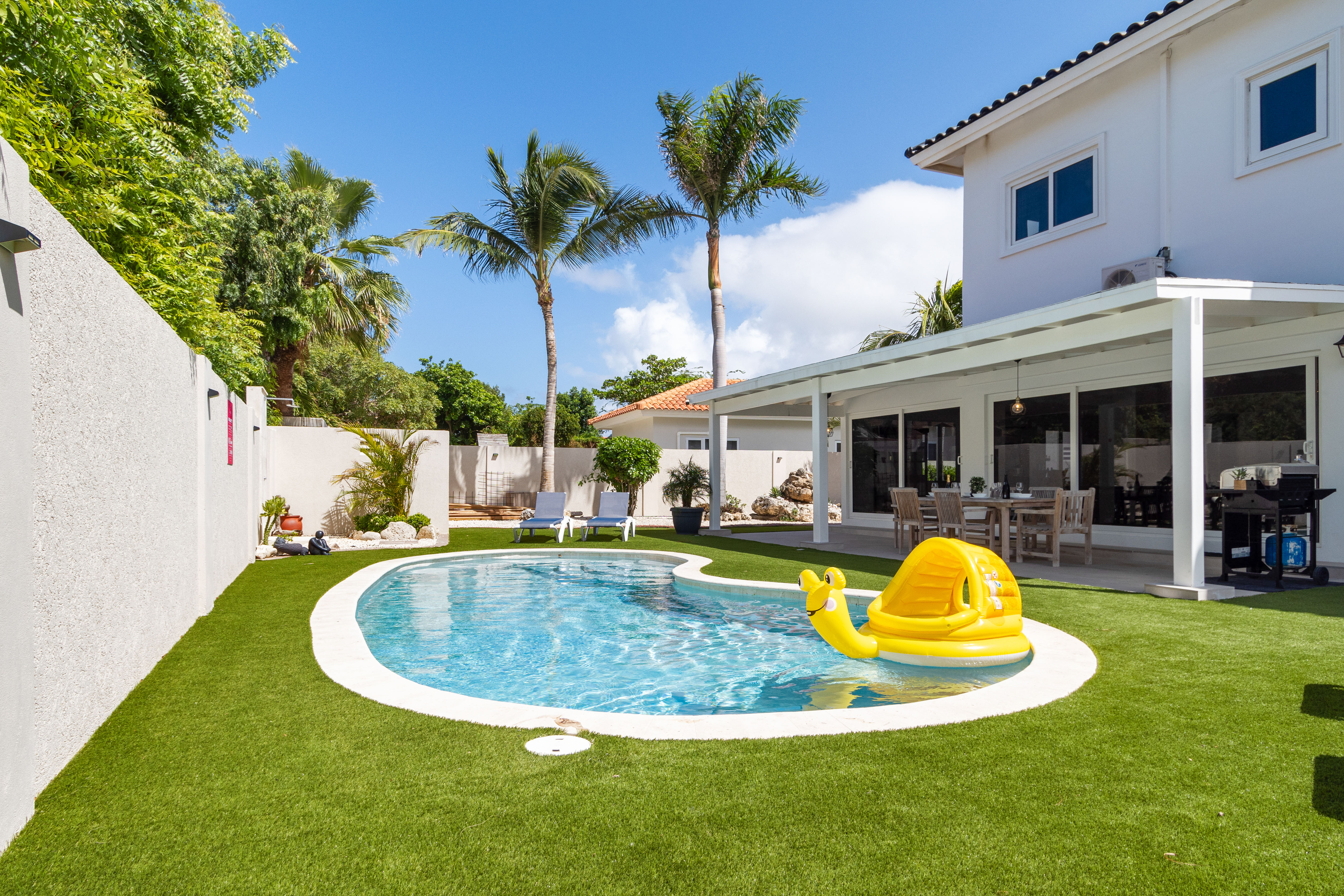 Chic Pool of the 5BR house in Noord Aruba - Some areas offer easy access to grills - Palm trees and tropical plants enhance the vacation feel - Maintained with clear guidelines
