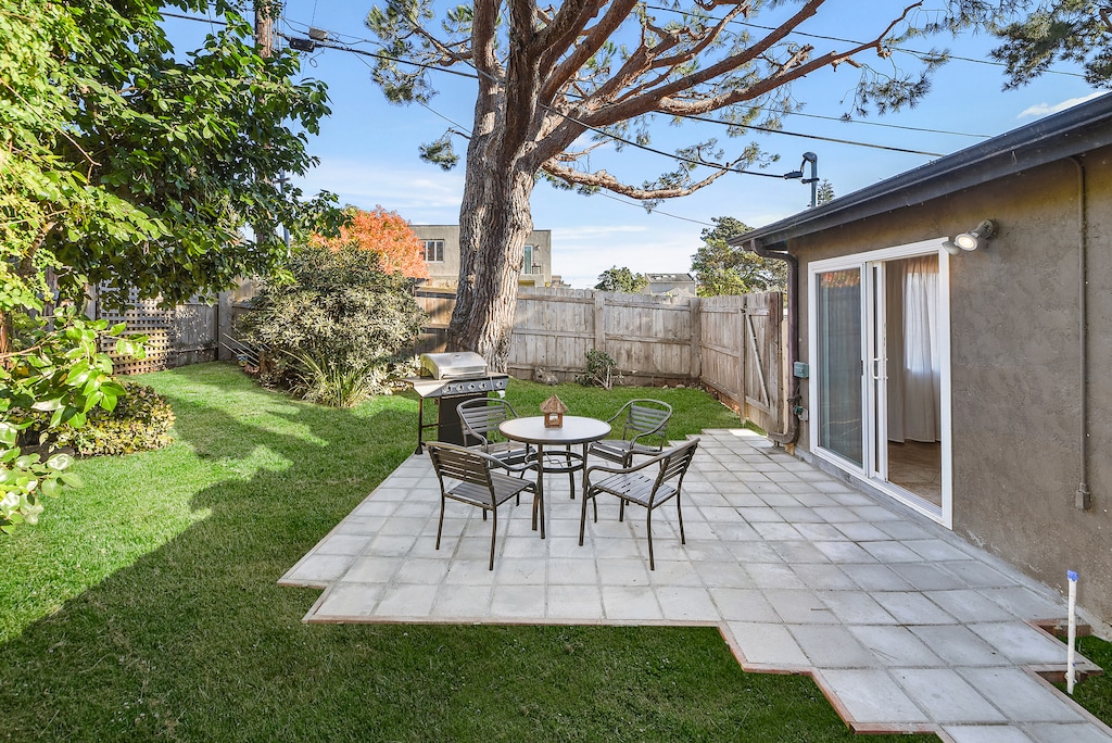 The tiled patio features outdoor seating, making it a perfect spot for BBQs and relaxing in the private yard.