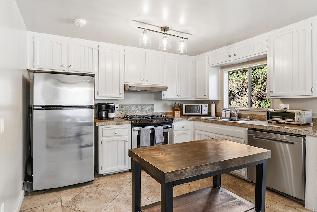 Seashore Delight’s fully equipped kitchen includes stainless steel appliances for hassle-free meal prep.