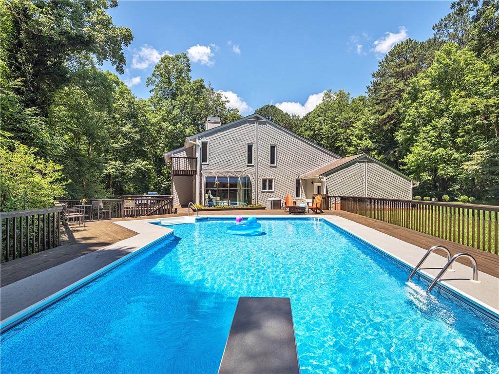 Enjoy a large fenced-in heated pool with a diving board and plenty of outdoor seating!