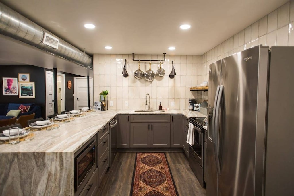 Large spacious kitchen with all stainless steel appliances (fridge w/filtered water and ice maker, microwave, stove, dishwasher). Huge bar/countertop comfortably seats 5.