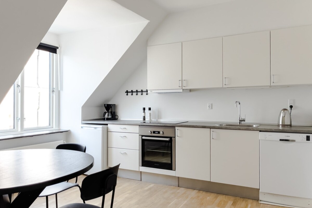 A stunning kitchen, where white walls and a clean, modern design create a fresh and airy atmosphere. The white cabinetry is sleek and elegant, providing ample storage space for all your kitchen essentials.