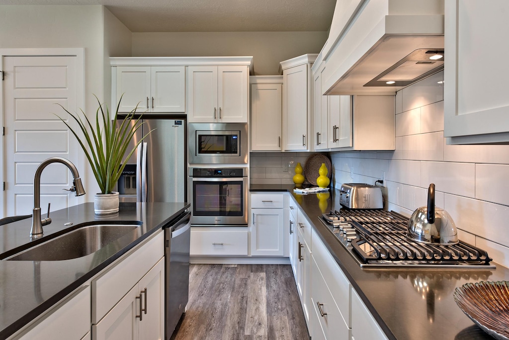 Side view of kitchen showing off the beautiful counter tops and stainless steel appliances.