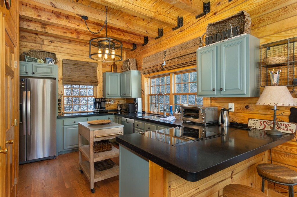 Sleek kitchen with bar seating for 2, a dishwasher, and 2 types of coffeemakers (standard drip & Keurig).