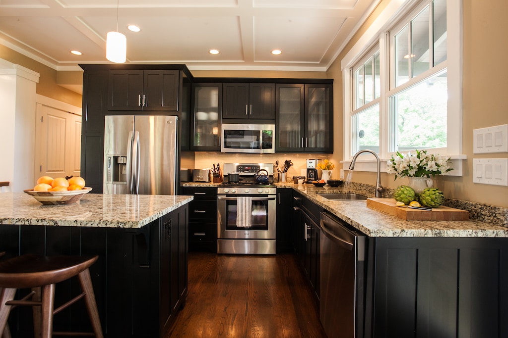 Custom kitchen with granite counters and black cabinets—fully equipped and functional.