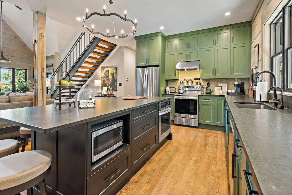 A beautifully appointed chef's kitchen boasts stainless-steel appliances, abundant prep space, and an island with bar seating—ideal for casual meals or entertaining .