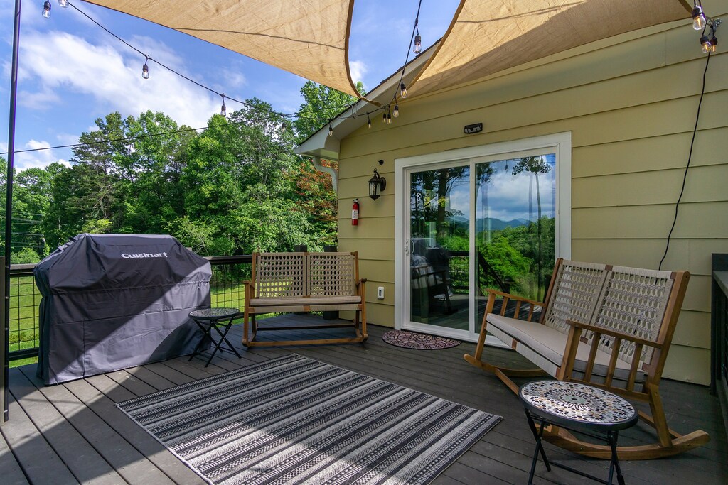 Deck shade sales, two rocking love seats, and a gas grill.