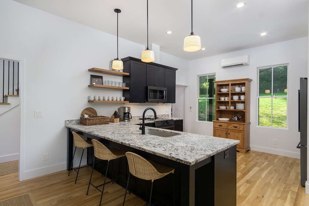 Sleek kitchen with bar seating for 3, a dishwasher, coffee grinder & 2 types of coffeemakers (French Press & Standard Drip).