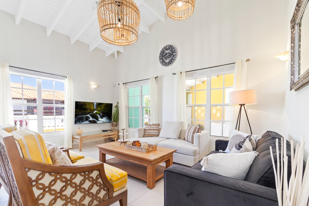 Lavish Living area of the 3BR House in Noord, Aruba - Cosy sofas - Wonderful surrounded by large windows for light, air and beautiful views - Fabulous sitting with panoramic decor - Availability of TV and Netflix - Majestic chandeliers