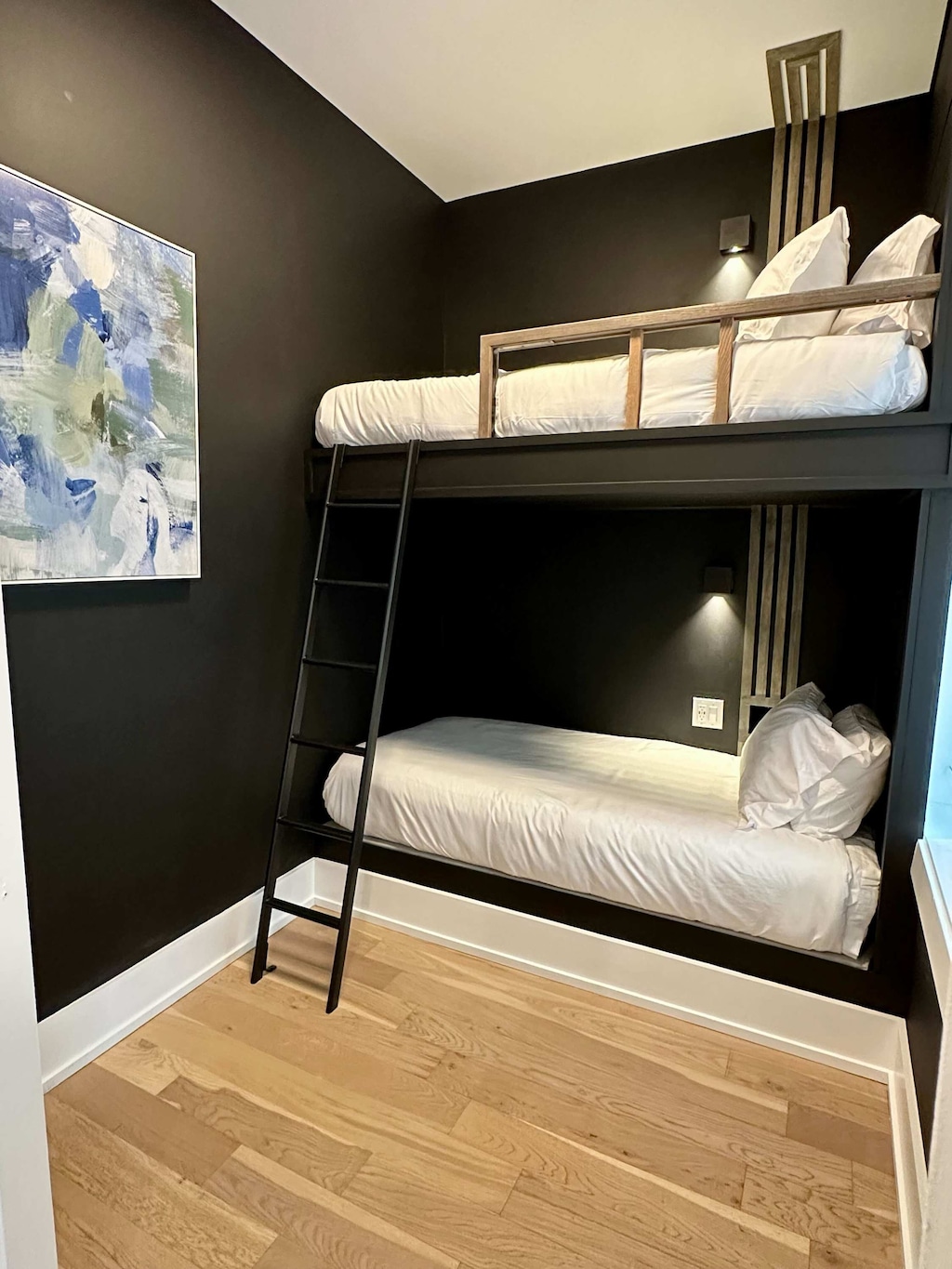 Tucked away in a cozy nook, this twin-over-twin bunk bed offers a snug and inviting spot for kids or grown-up guests to unwind and recharge.