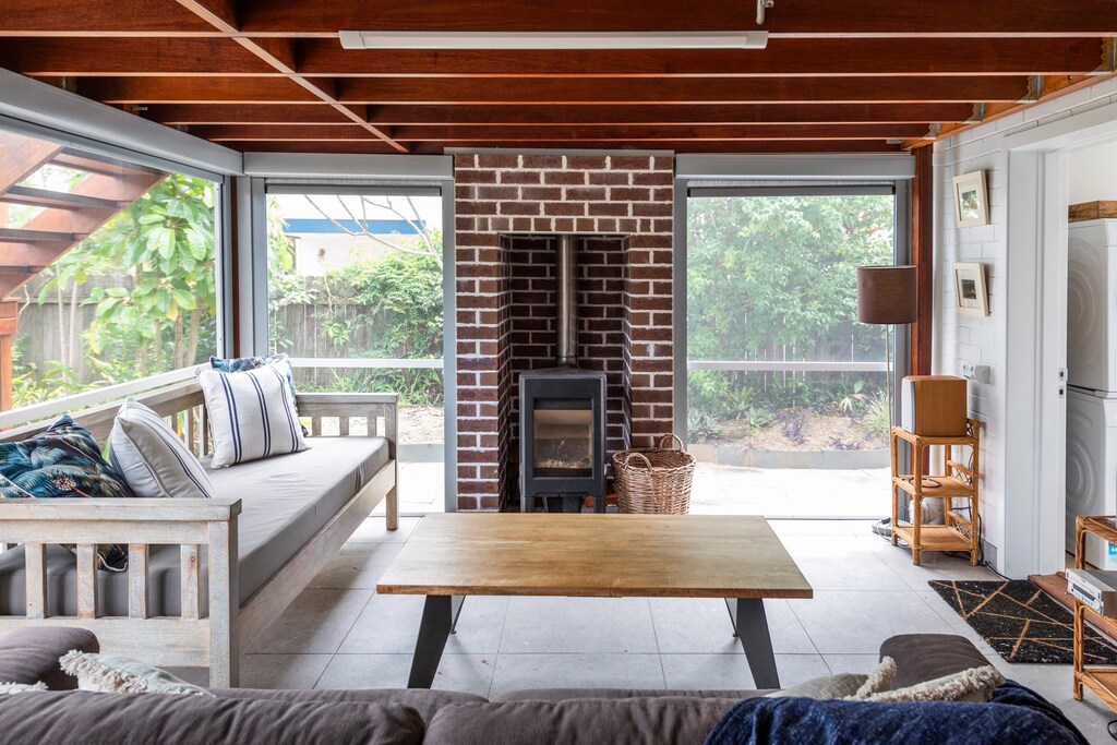 Captain's Haven - Yamba pet-friendly accommodation - Downstairs rumpus room with a fire place & direct access to yard & hot tub