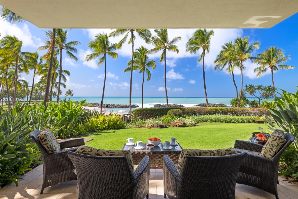 Enjoy your morning coffee in this serene outdoor seating area, with stunning views of the ocean and palm trees at Ko Olina Beach Villas B109.
