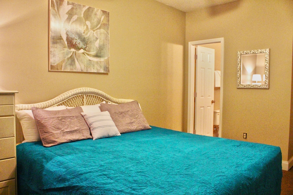 Spacious bedroom with a king-size bed, soft lighting, and peaceful decor for a restful Myrtle Beach stay.