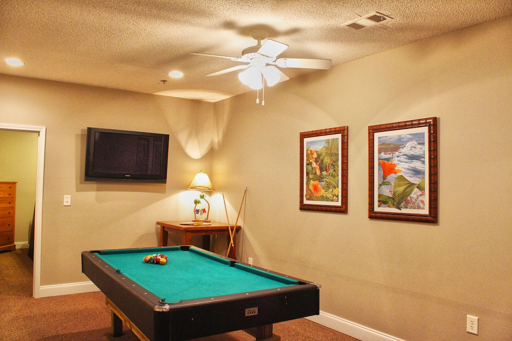 Enjoy a casual evening in this cozy game room featuring a pool table and mounted TV—great for guests of all ages.