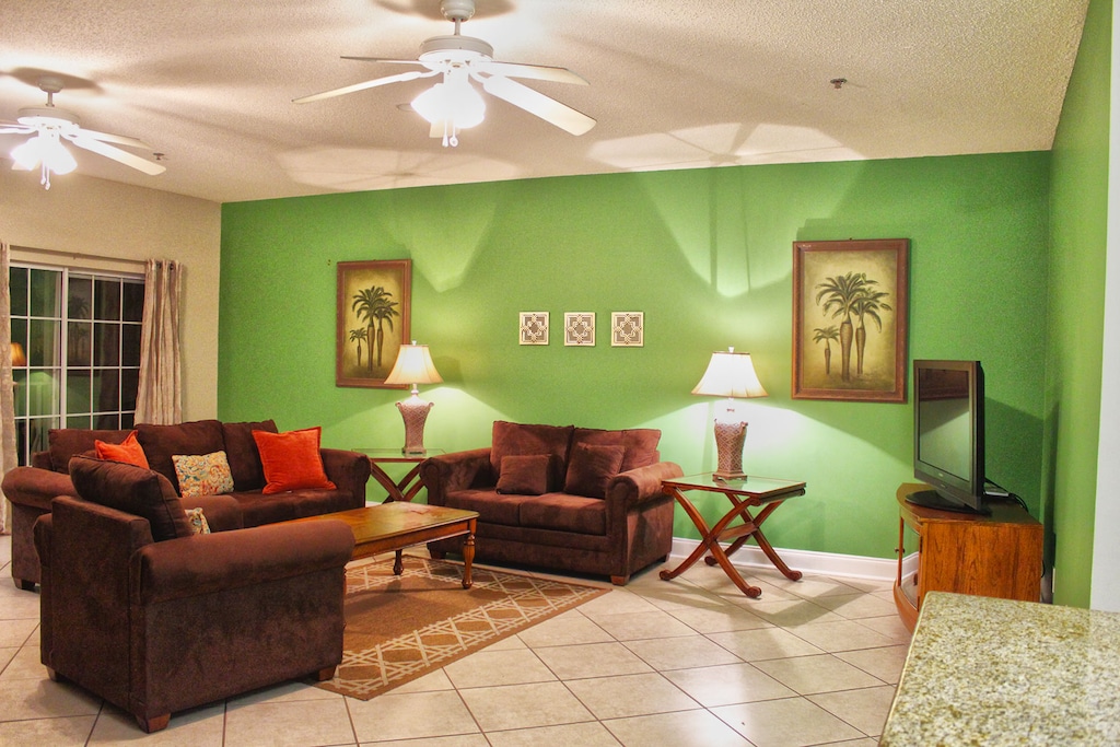 Tropical-inspired living room with bright green accent wall and comfy seating for relaxing after the beach.