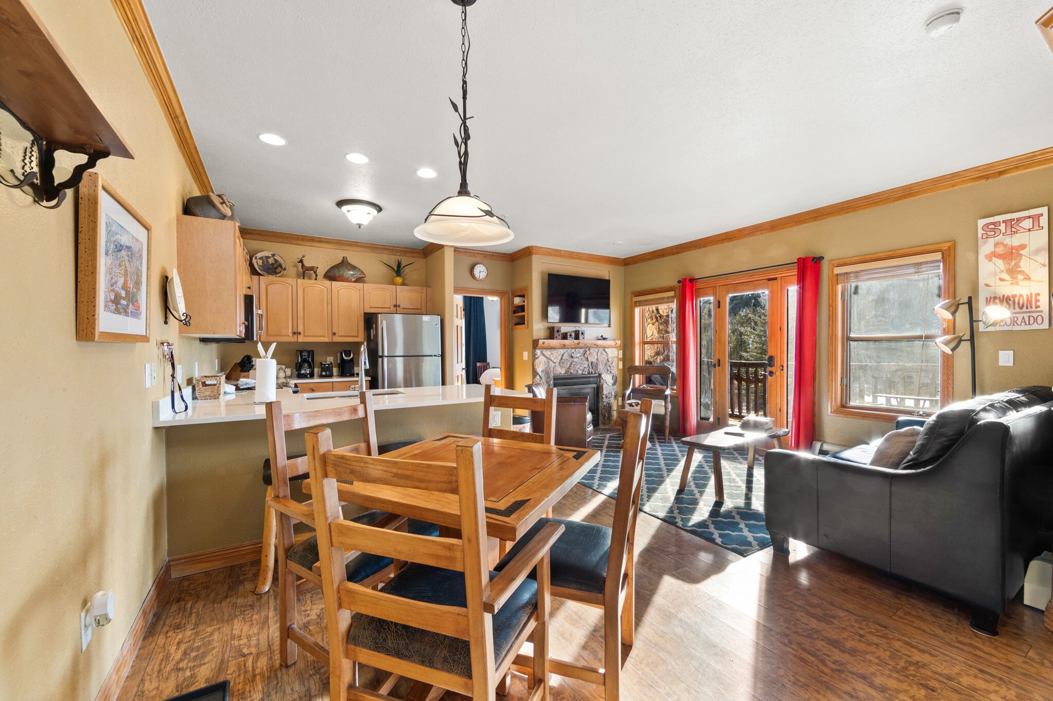 Sunny living area with sleeper sofa, flatscreen TV, gas fireplace, and walk-out deck. 