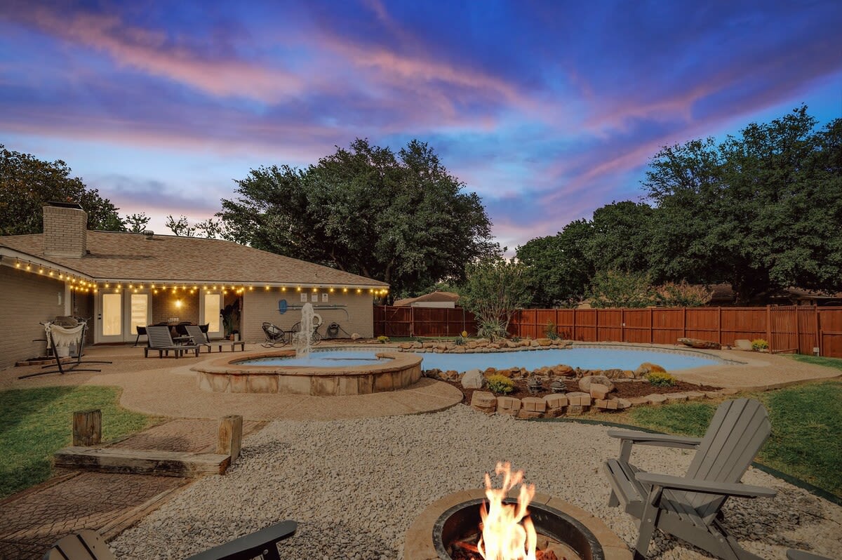 Check out this beautiful backyard oasis! Equipped with a pool, patio, fire pit, loungers, and a hammock, what more could one ask for?!