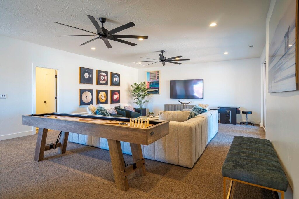 Upstairs living room with shuffleboard, an arcade, sofa seating, TV, and games!