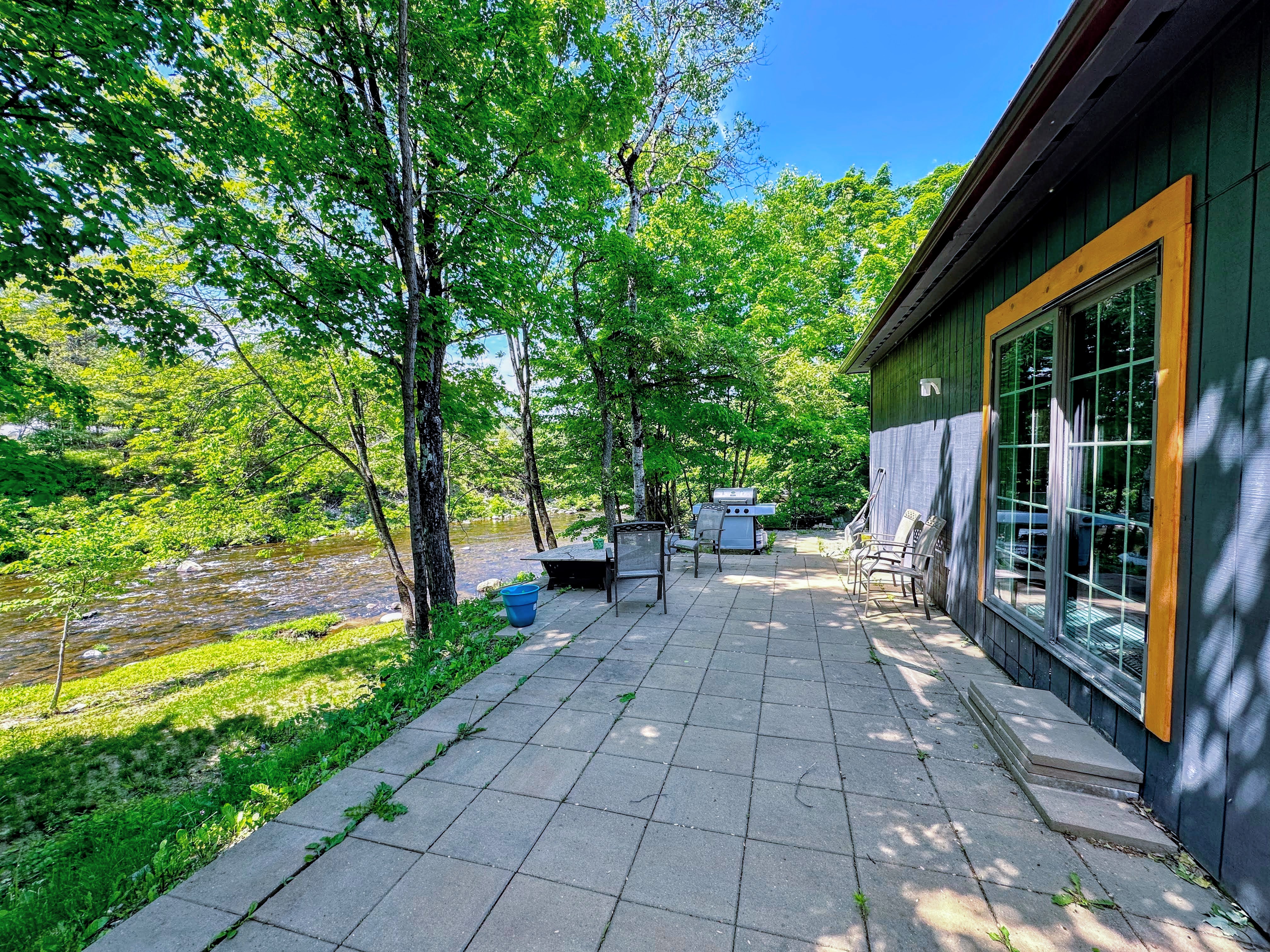 Patio along the river with fire pit and grill