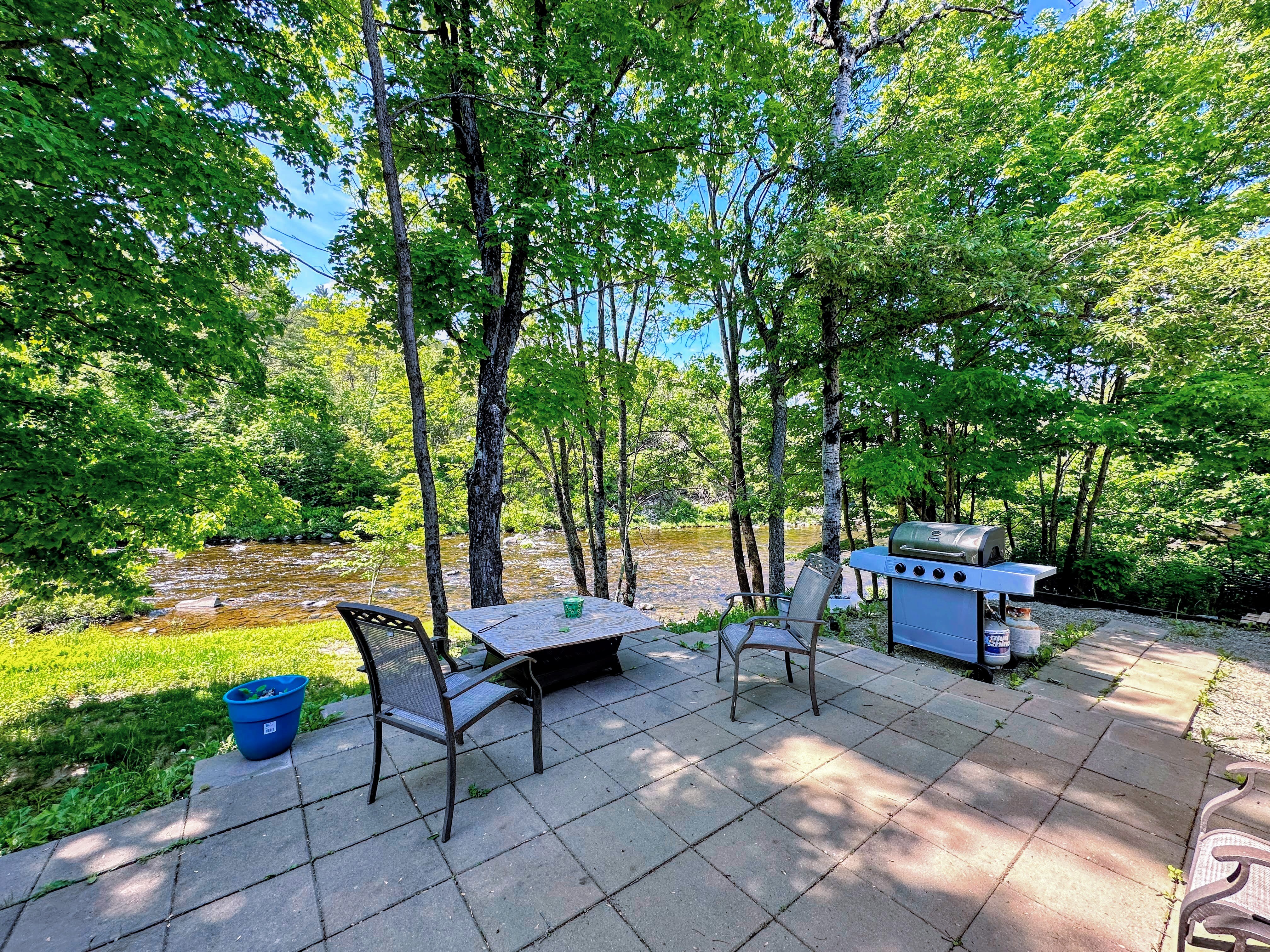 Patio along the river with fire pit and grill