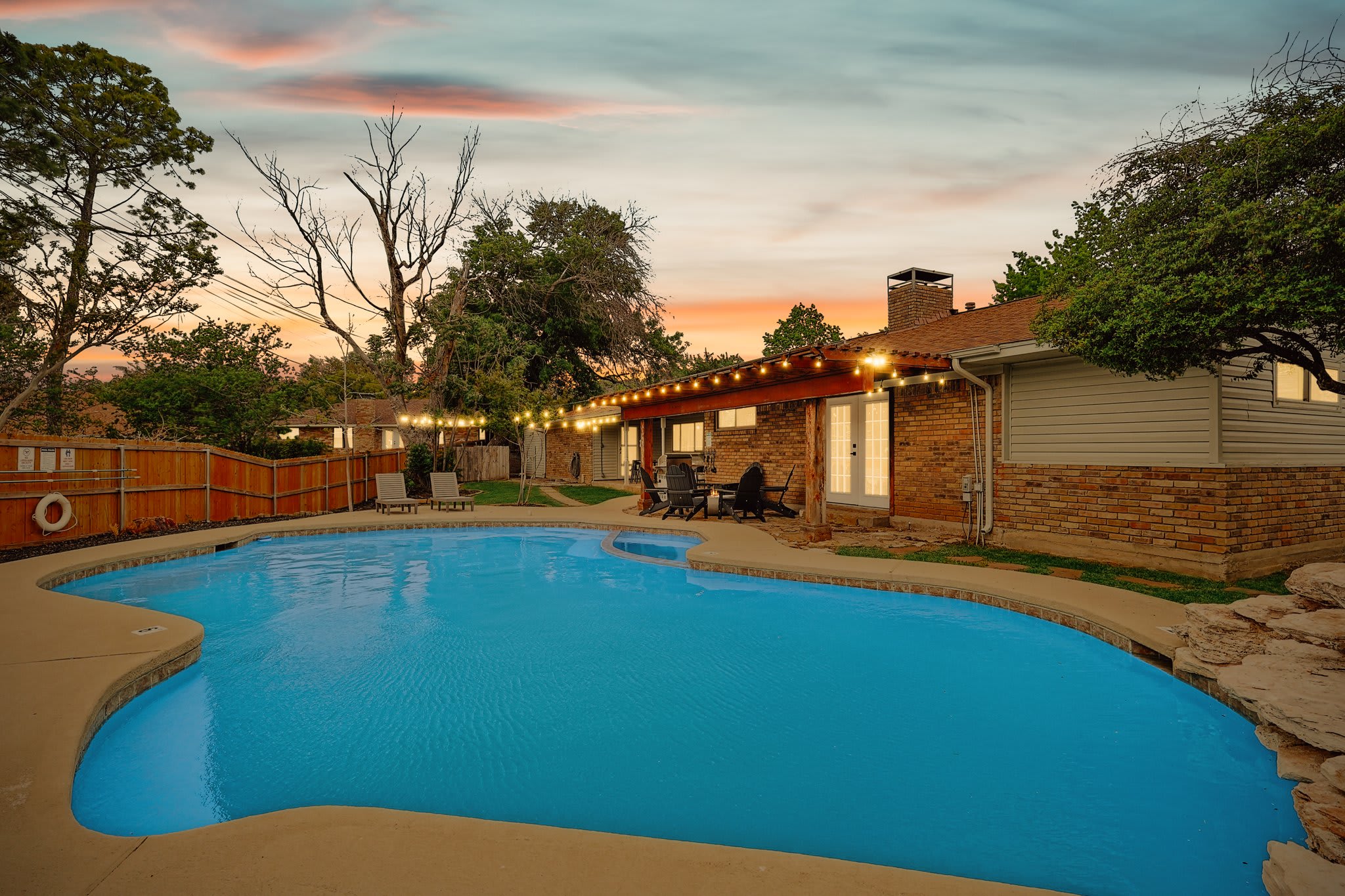 This is a backyard meant for good times under the sun with an outdoor swimming pool, a fire pit, a furnished patio, a conversation set, a BBQ grill, and poolside loungers!