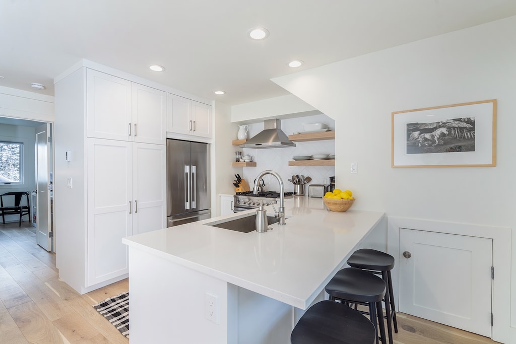 The kitchen is equipped with plentiful silverware, glassware & plates.