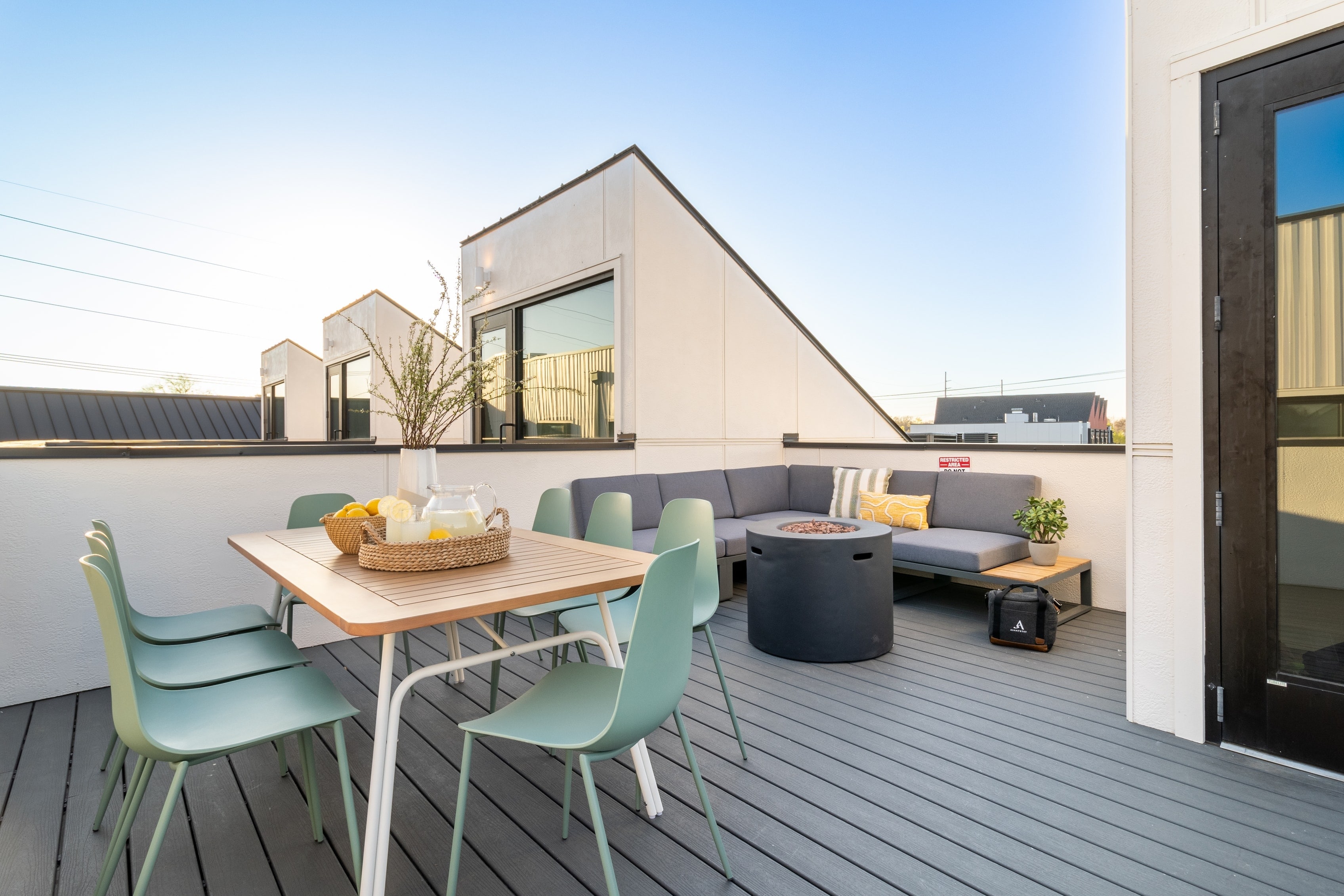 Private rooftop deck features a fire pit, comfortable seating area, and outdoor dining table.