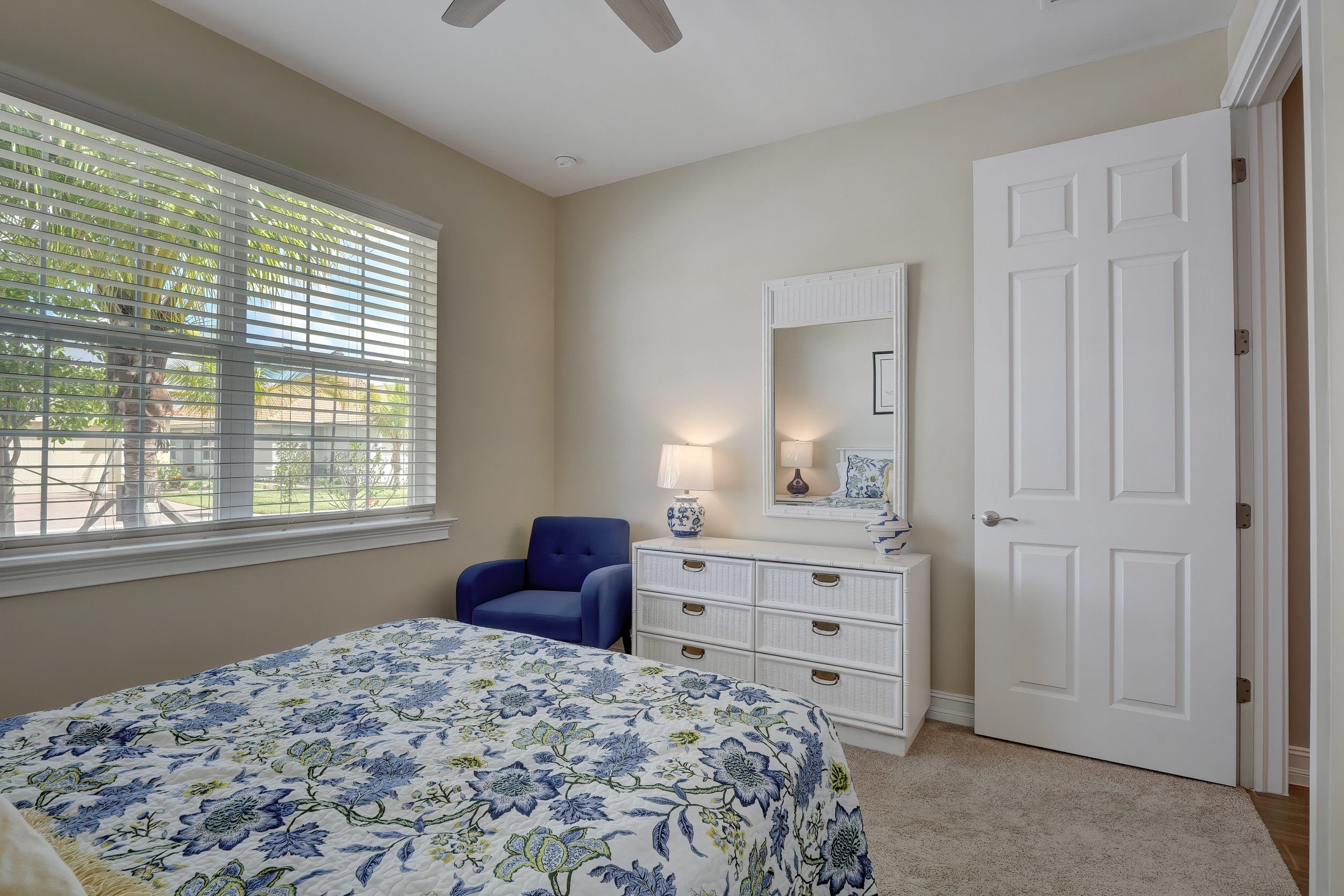 The Second Bedroom Faces the Front of the Home And Has A Dresser and a Accent Chair