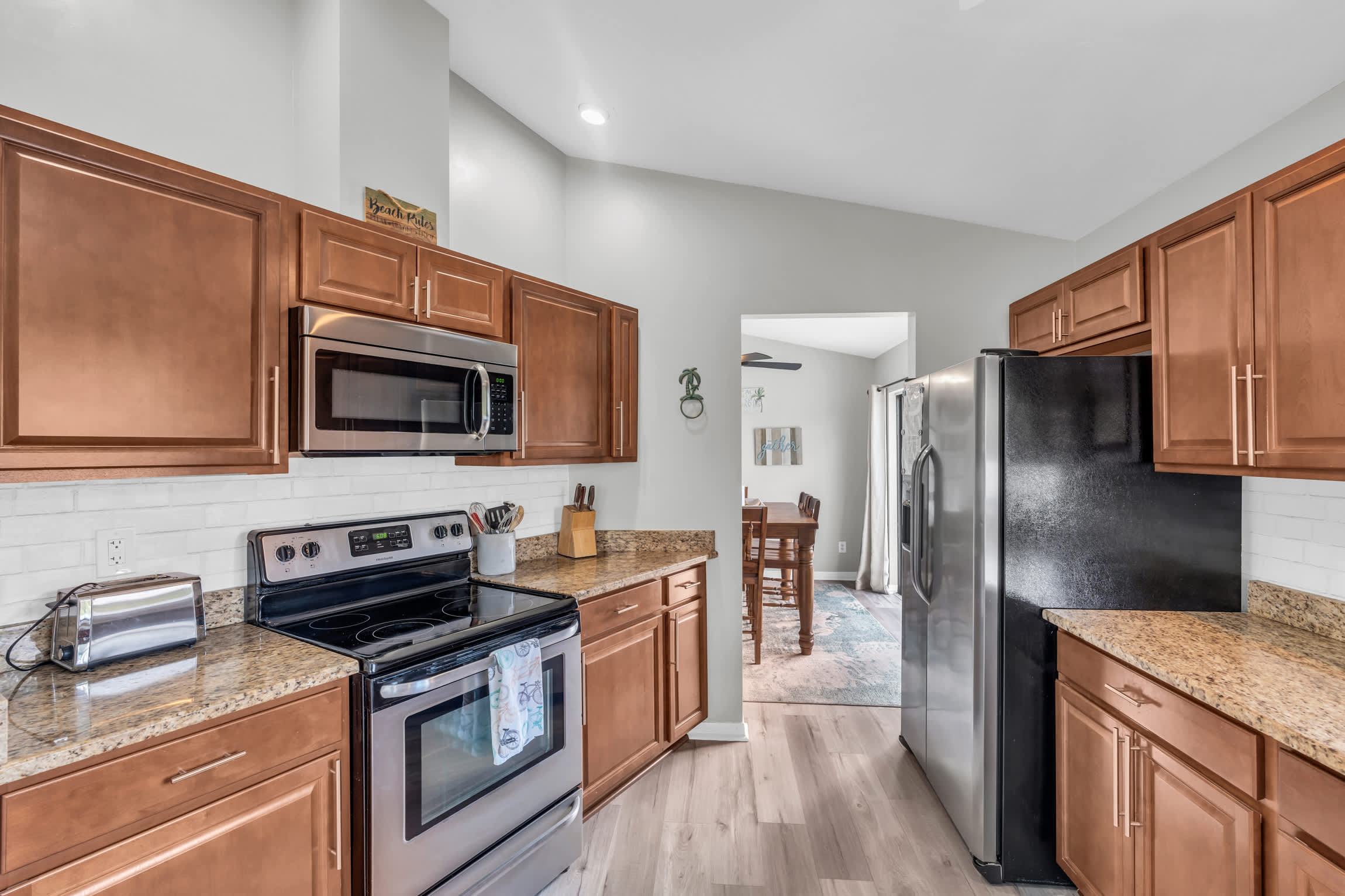 The kitchen has stainless steel appliances, granite counters and hardwood cabinets 
