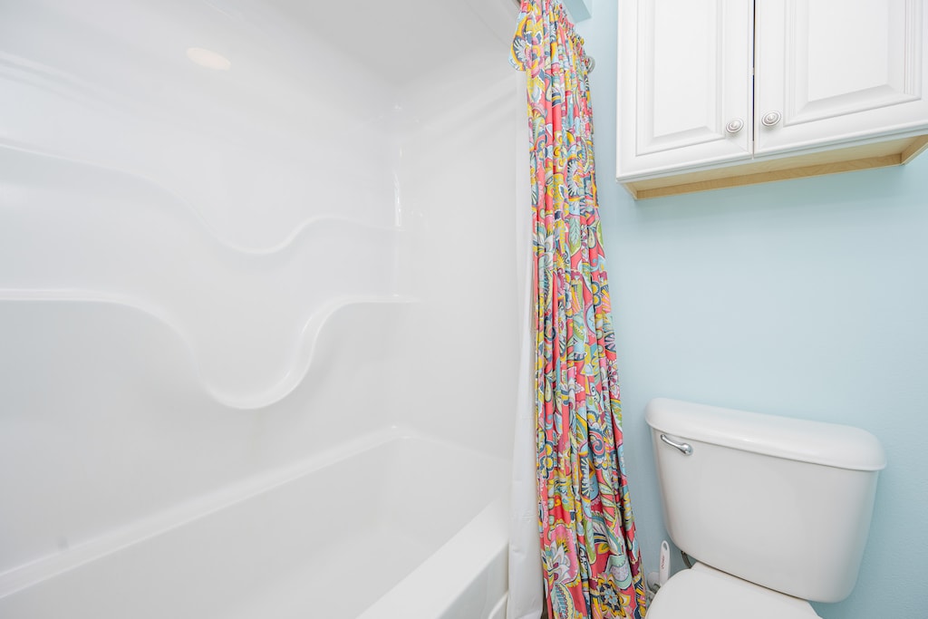 Vibrant shower space with a colorful curtain for your daily routines in this guest bath