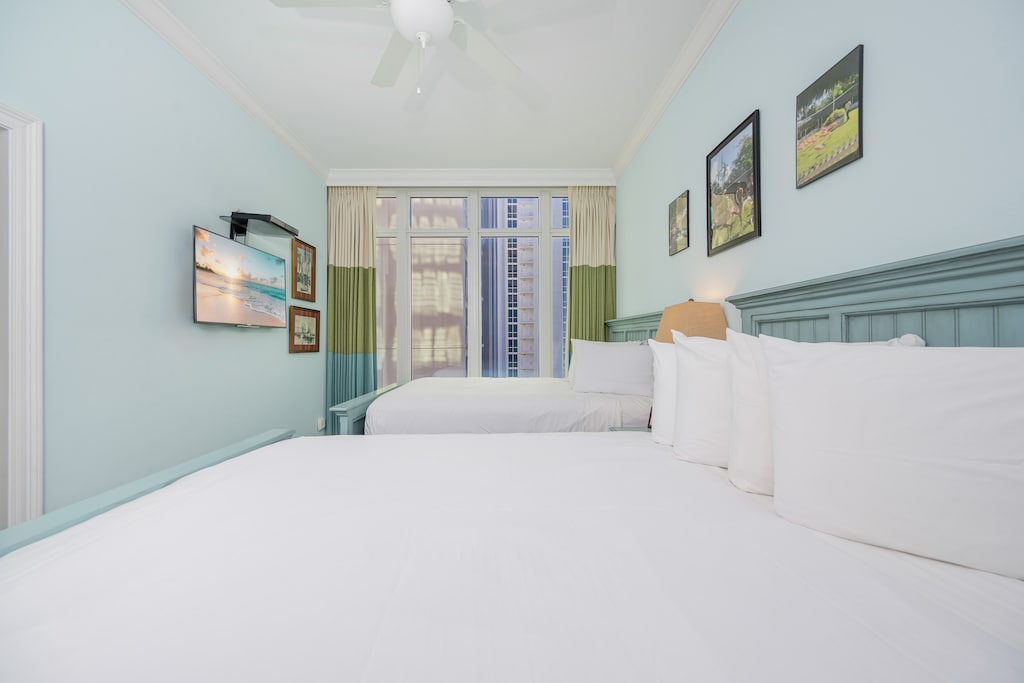 Rest in this inviting guest room with two queen beds, soft linens, and a TV