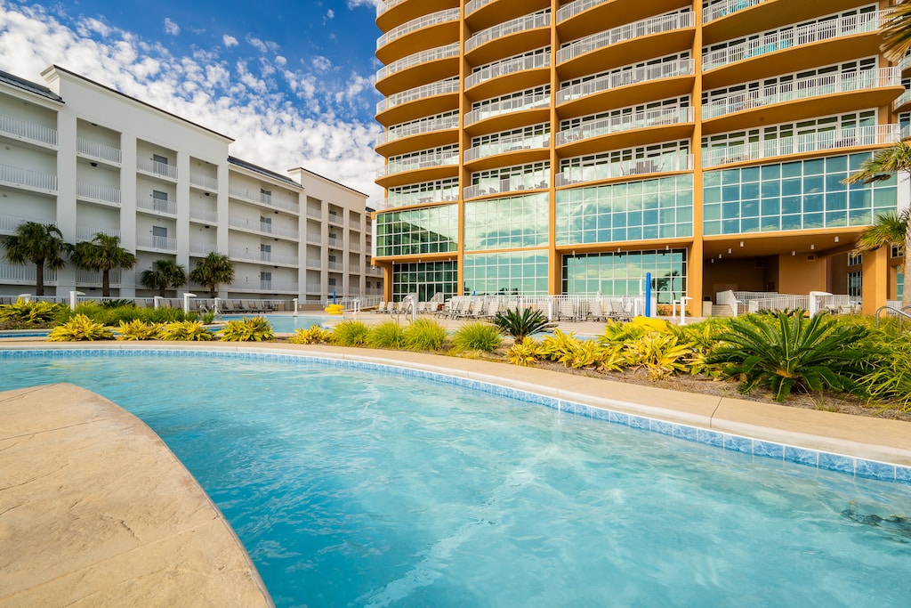 Float along the lazy river with lush landscaping and a stunning view of the beachfront at Phoenix Gulf Towers in Orange Beach