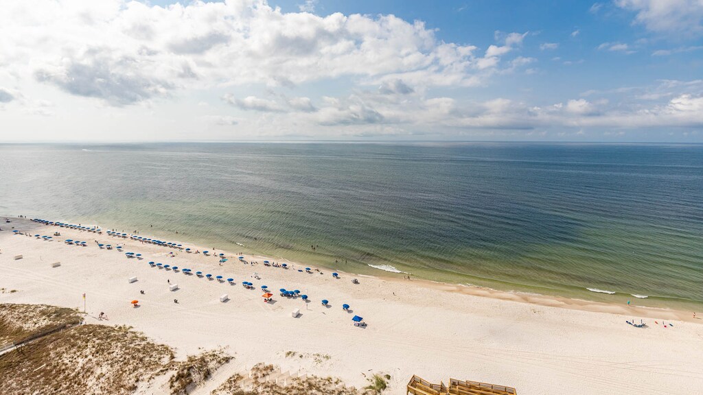 Savor gulf breezes while watching colorful umbrellas and gentle waves along the beach below