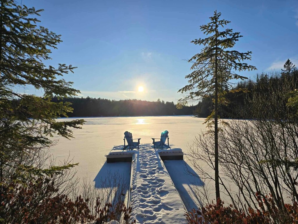 Experience sun-drenched quiet. Lakeside solace, winter's gentle embrace.