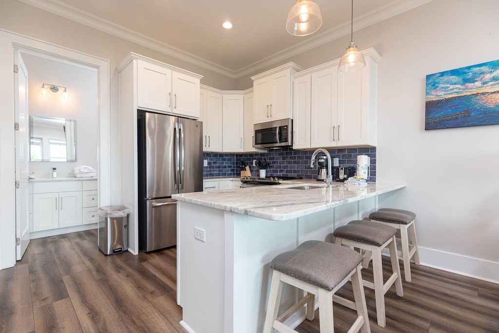 This modern kitchen features stainless appliances, granite countertops, and a cozy breakfast bar perfect for casual dining