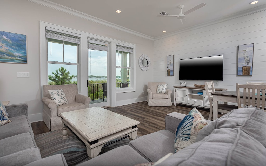 This inviting living area features a large TV, comfortable seating, and a serene lagoon view through expansive windows