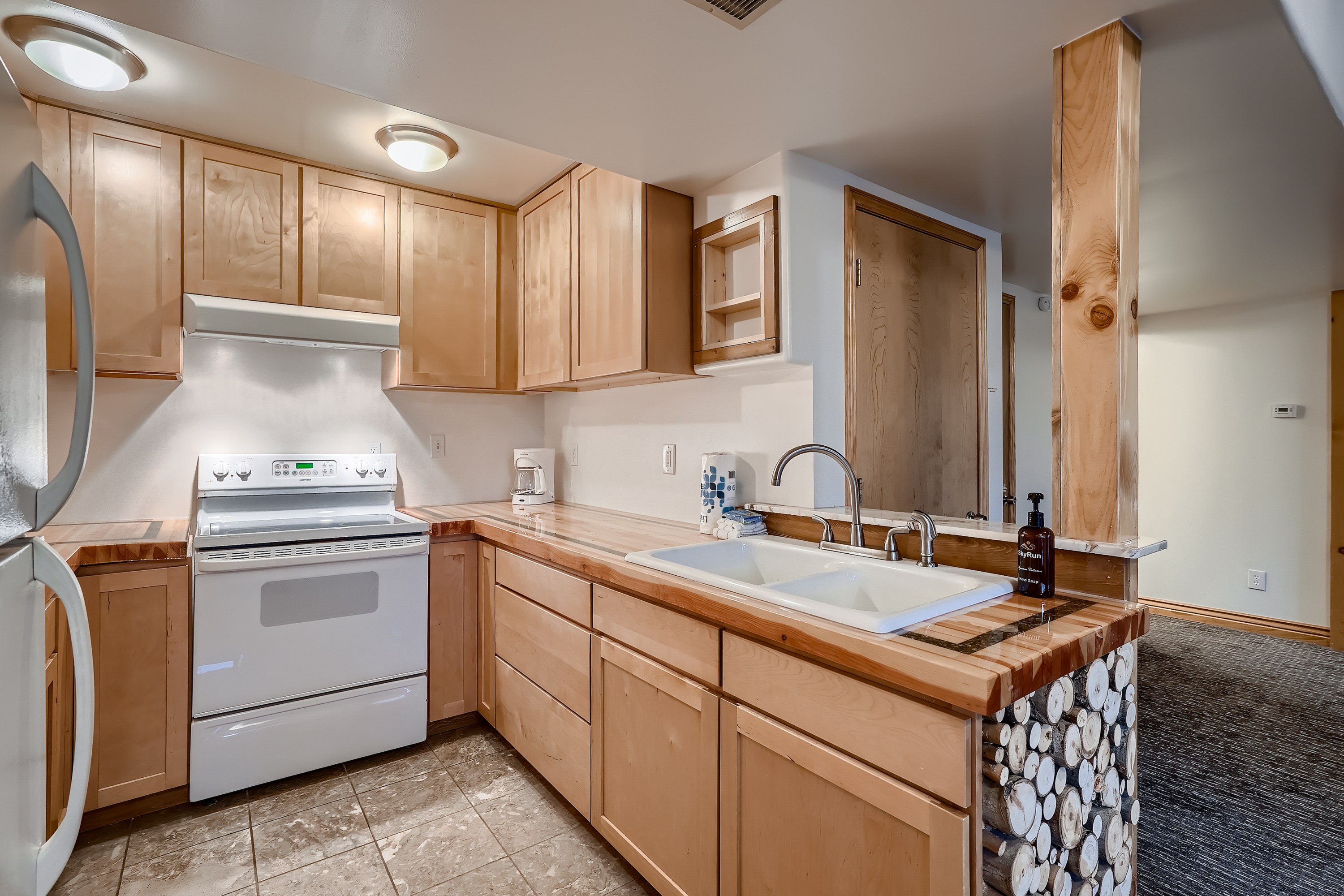 A kitchen with wood cabinets and a sink.