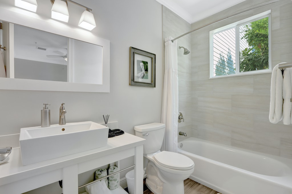 Bedroom 1 Ensuite Bathroom | Single vanity sink, shower tub combo, modern coastal design.