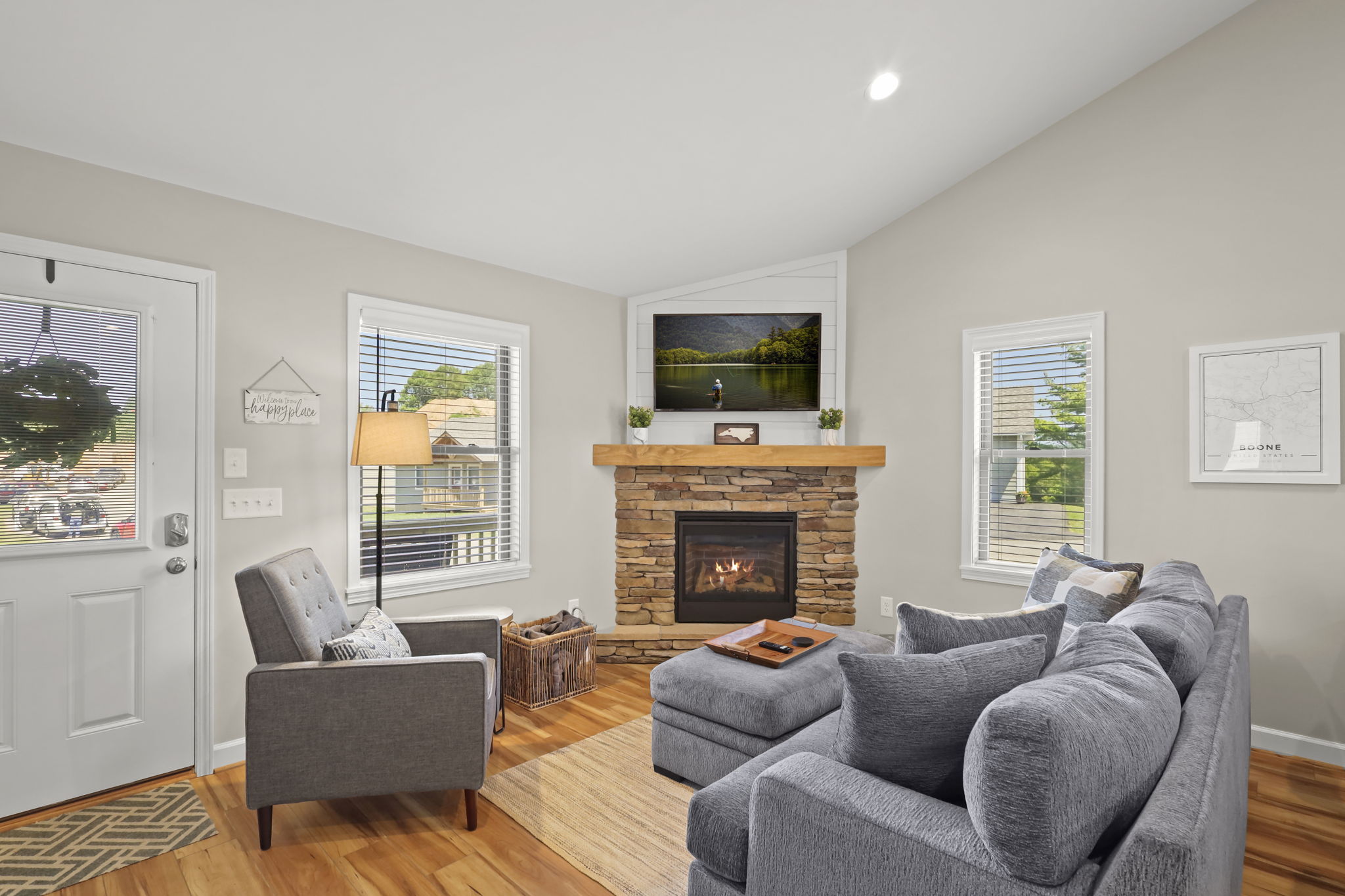 Cozy up: Plush sofa, chic chair, TV, deck views, and a crackling indoor fireplace.